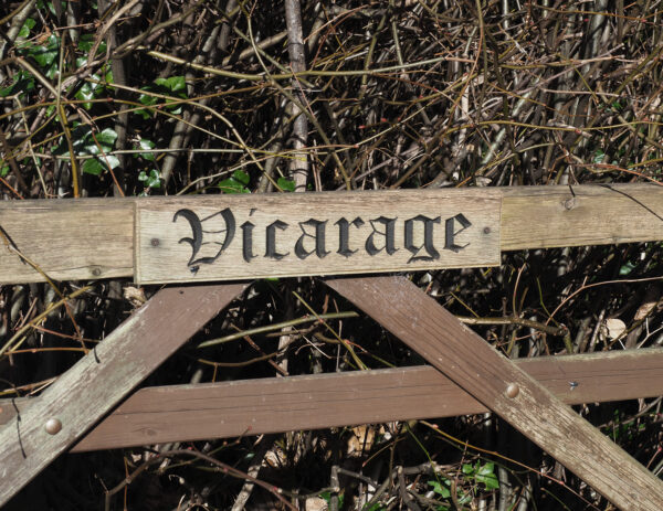 Sign saying vicarage on gate