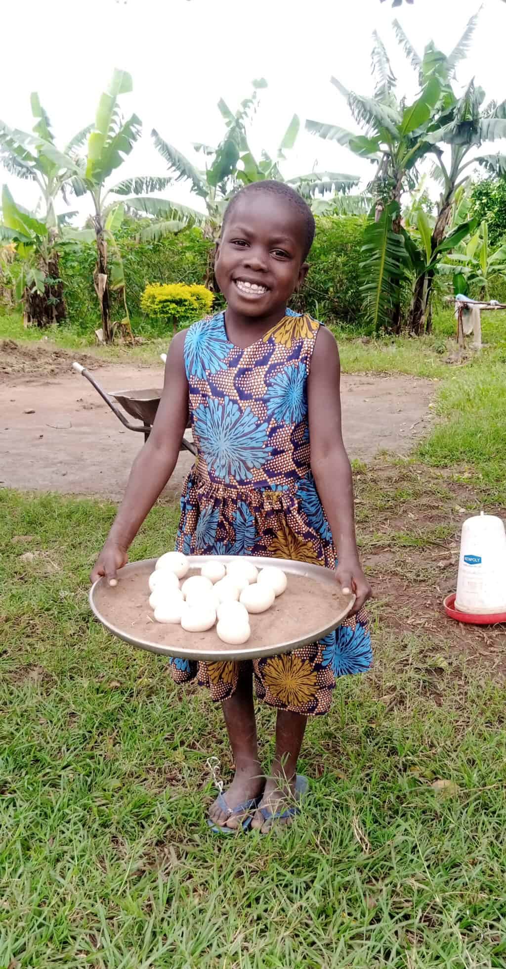 Ugandan girl holding a bowl of eggs