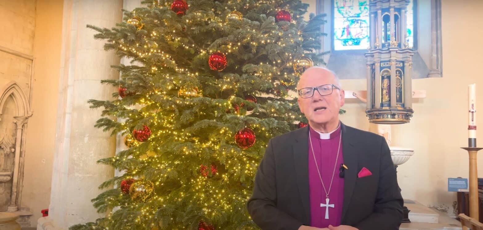 The Bishop of St Albans, Alan Smith, in front of a Christmas tree at St Albans Cathedral